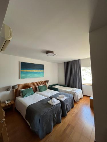 two beds in a hotel room with at Hotel Paulo VI in Rio Maior