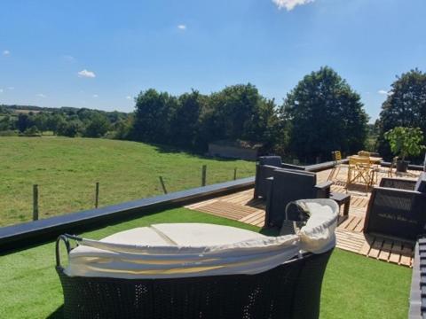 a backyard with a hammock and a table in a field at Le pré en bulles in Lespesses