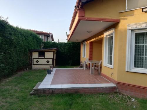 a patio with a table and chairs next to a house at Villa ARDEN in Kartepe