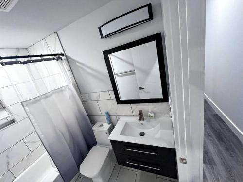 a white bathroom with a sink and a mirror at Yanne's Place - Philabundance Views in Philadelphia
