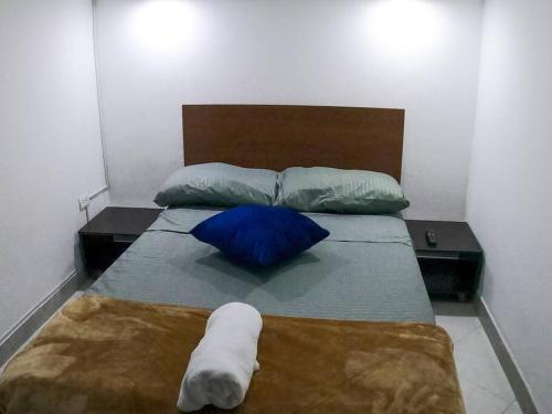 a bed with two pillows and a blue pillow at Fresco Aparta estudio Envigado 101 in Envigado