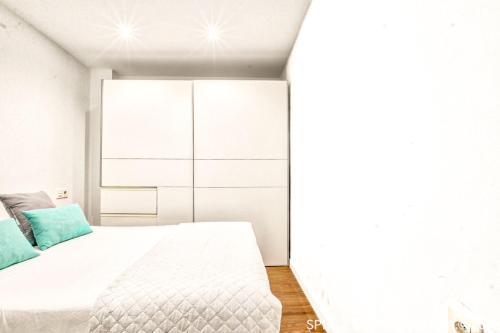 a bedroom with a white bed and a white cabinet at Acogedor Loft Centro Murcia in Murcia