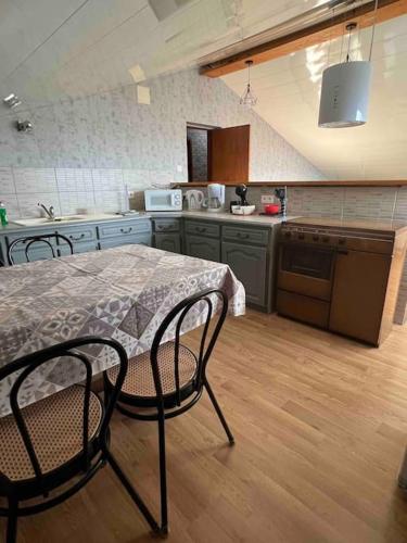 une cuisine avec une table et des chaises dans une cuisine dans l'établissement Appartranquille, à Breuches