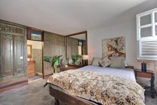 una camera con un grande letto e una grande finestra di Cottage Saudade - Les Terres Basses a Marigot