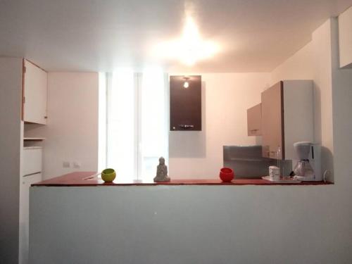 une cuisine avec des armoires blanches et un comptoir dans l'établissement appartement Netflix parking gratuit climatisation, à Saint-Ambroix