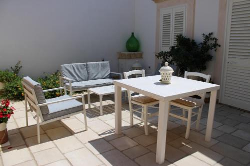 una mesa blanca y sillas en un patio en Le Dimore di Corte Madama, en Casarano