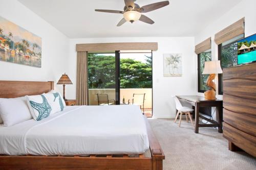1 dormitorio con cama, escritorio y ventana en K B M Resorts- KGV-14V3 Oversized 2Bdrm sweeping ocean views remodeled premium upgrades, en Kapalua