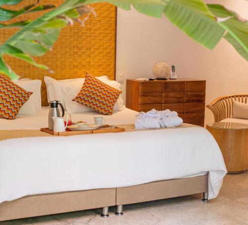 カルタヘナ・デ・インディアスにあるCasa Claver Loft Boutique Hotelのホテルルーム ベッド1台(食料トレイ付)