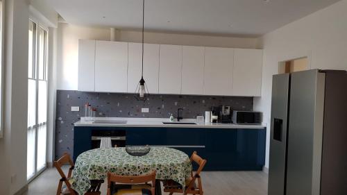 una cucina con tavolo e una cucina blu e bianca di Seveso appartamento nuovo tra Milano, Monza e Como a Seveso