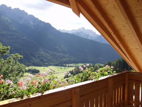 a balcony with a view of a valley with mountains at Hotel Schopfenhof in San Candido