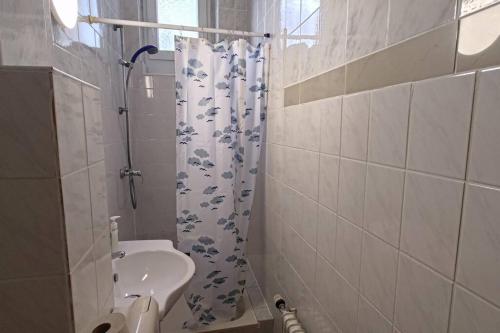 a bathroom with a sink and a shower curtain at 60qm-Wohnung im 2. OG mit Balkon in Duisburg