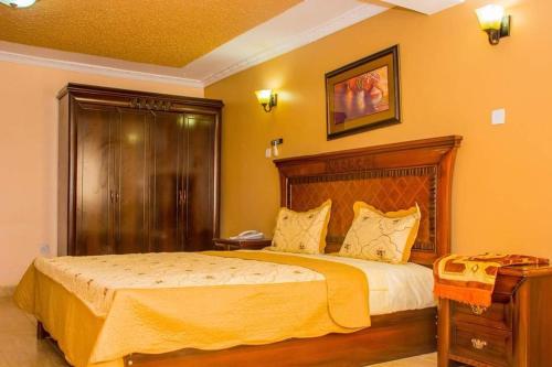 a bedroom with a large bed with a wooden headboard at Tana Garden Hotel in Garissa