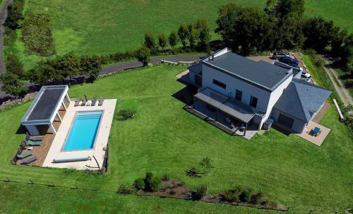 an aerial view of a house with a swimming pool at Le Gîte "Aubrac" Haut de gamme, Jardin, Piscine in Gabriac