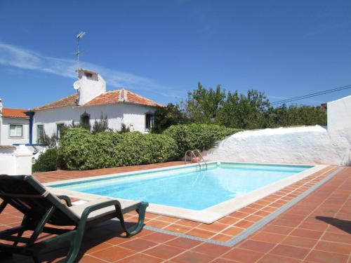 a swimming pool in front of a house at Vila Casa Do Sobral in Óbidos