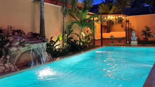 a swimming pool with a waterfall next to a house at Casa Mira Boutique Villa in Mirissa