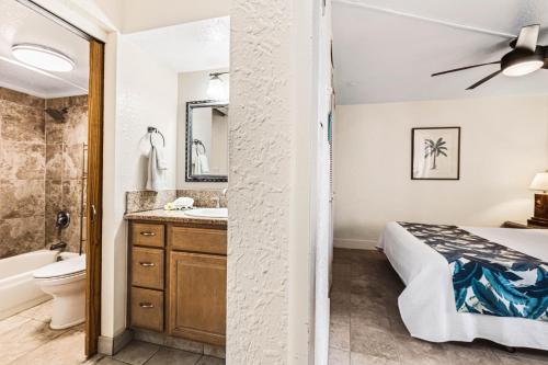 a bathroom with a bed and a sink and a toilet at Paki Maui 414 in Kahana