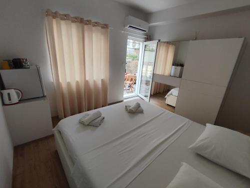 ein Schlafzimmer mit einem weißen Bett mit zwei Handtüchern darauf in der Unterkunft Zorić Apartments & Rooms 2 in Dubrovnik