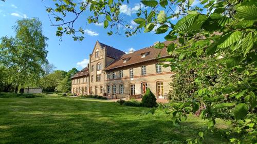 a large brick building with a green yard at FeWo "Falter" im Kunstgut Krahne in Krahne