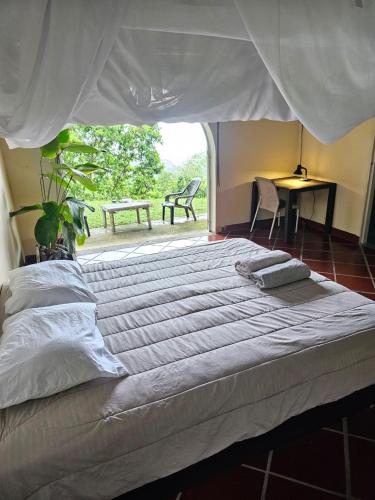 a large bed in a bedroom with a table and chairs at Cabaña Mountain Ocean View Minca in Minca