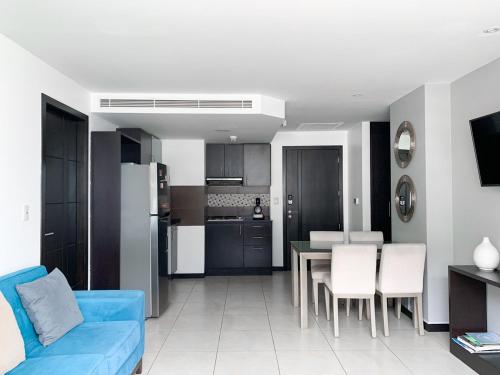 un soggiorno con divano blu e una cucina di Penthouse de 2 habitaciones con vista al rio y parking a Guayaquil