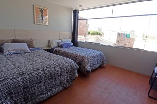 a hotel room with two beds and a large window at Depa de Estreno en Arequipa in Arequipa