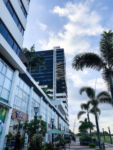 a tall building with palm trees in front of it at Depa Puerto Santana,AC,WIFI,Bares,Restaurante,segurida 24-7 in Guayaquil