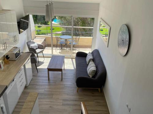 a living room with a black couch and a table at Seaside View Apartment in Estepona