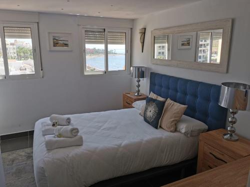 a bedroom with a large bed with a blue headboard at Seaside View Apartment in Estepona