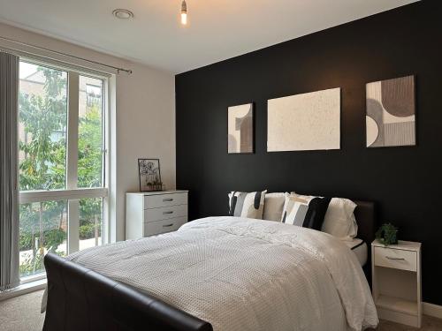 a bedroom with a black accent wall and a bed at Deluxe Spacious Room Near London Bridge! in London