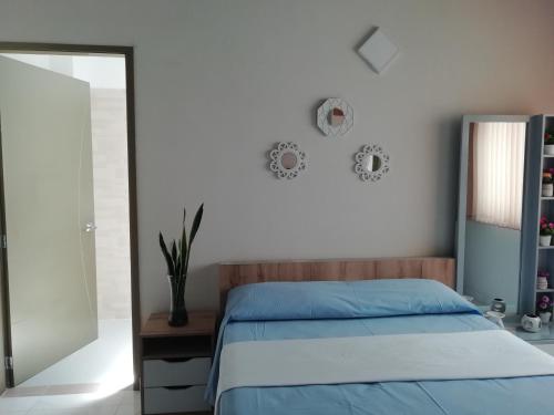 ein Schlafzimmer mit einem blauen Bett und einem Spiegel in der Unterkunft ALAMEDA MI DESCANSO in Carmen de Viboral
