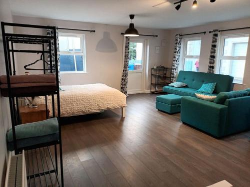 uma sala de estar com uma cama e um sofá em Tummock Studio perfect for exploring the North coast em Kilraghts