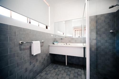 ein Bad mit einem Waschbecken und einem Spiegel in der Unterkunft Island Palms Motor Inn in Forster