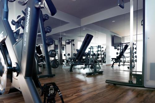 un gimnasio con máquinas de correr y espejos. en Hotel Yoru, en Querétaro