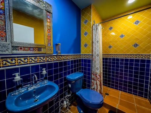 a bathroom with a blue toilet and a sink at Hotel Cantaritos in Rosarito
