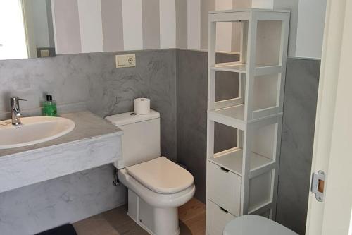 ein Badezimmer mit weißer Toilette und Waschbecken in der Unterkunft Villa Lux Finestrat in Finestrat