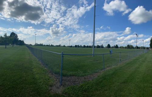 a chain link fence in the middle of a field at Illini Inn & Suites in Rantoul