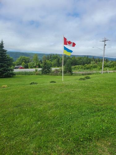 a flag in a field with a canadian flag at Kelly's View Motel in Boularderie East