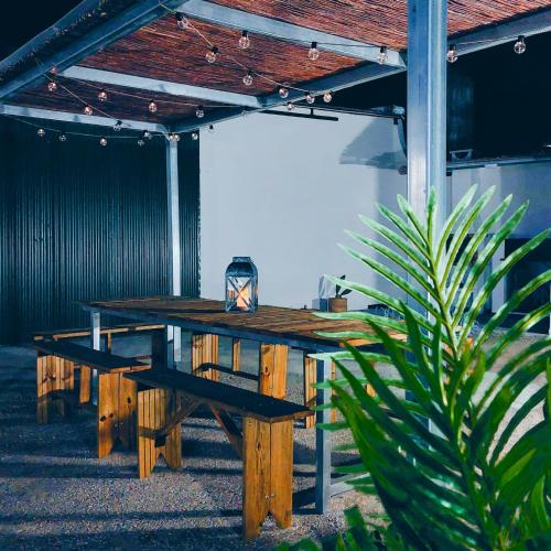 a wooden picnic table sitting under a building with a plant at Casas da Olaria in Aldeia do Mato