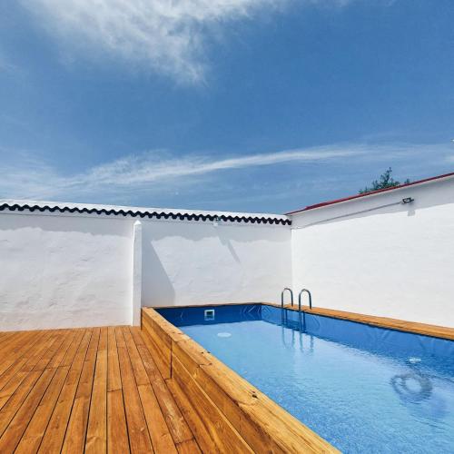 a swimming pool on a wooden deck next to a building at Casas da Olaria in Aldeia do Mato