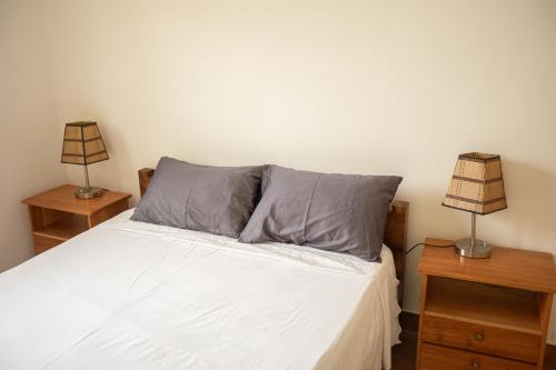 a bedroom with a white bed with two night stands at Apartamento Vista Mar in São Tomé