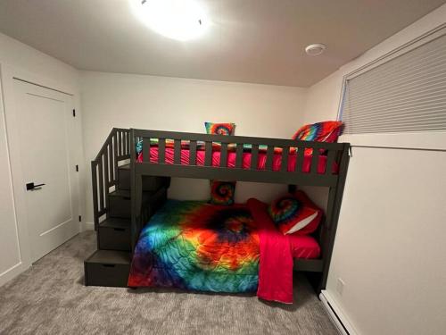 a bedroom with a bunk bed with a colorful blanket at The Royal Bay Escape: Cozy 2 bedrooms garden suite in Colwood