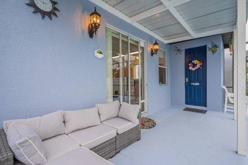 un sofá en un porche con una puerta azul en 5 Bedroom Villa l 12 min to Disney l Themed Rooms l Orlando Area en Davenport