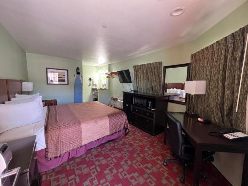Rancho California Inn Temecula في تيميكولا: غرفة في الفندق مع سرير ومكتب