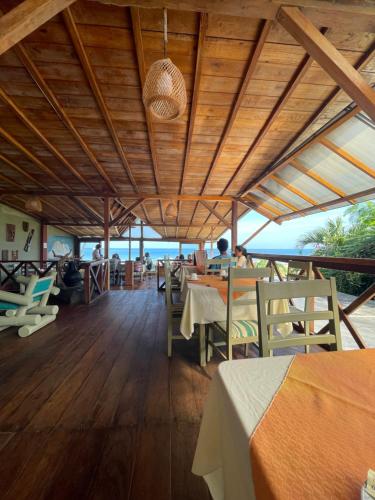 un restaurante con suelo de madera, mesas y sillas en Hotel Nantu Hostería, en Puerto López