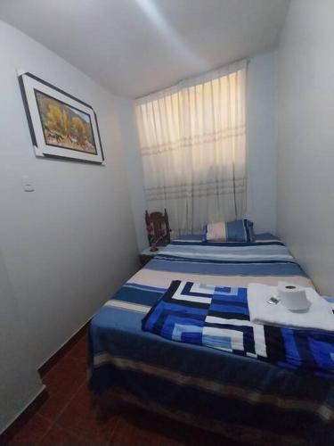 Habitación pequeña con 2 camas y ventana en D-201, en Moyobamba
