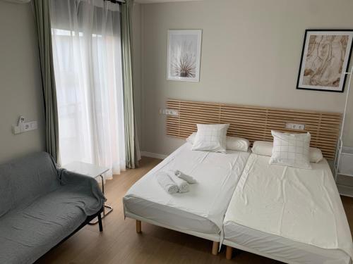 a bedroom with two beds and a couch at Plaza de España independent house in Barcelona