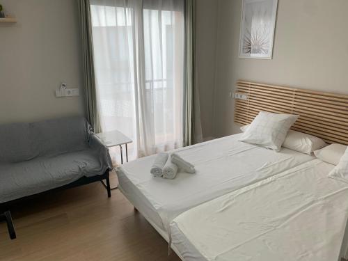 a bedroom with a large white bed and a couch at Plaza de España independent house in Barcelona