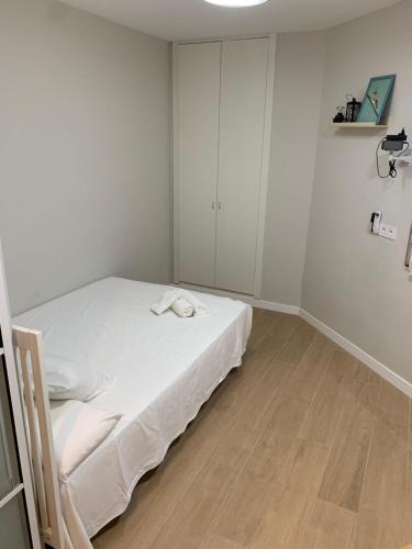 a white room with a bed and a wooden floor at Plaza de España independent house in Barcelona