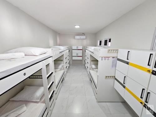 納塔爾的住宿－MANERO POUSADA e HOSTEL，一间设有白色双层床和白色橱柜的客房