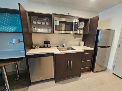 a small kitchen with a sink and a refrigerator at Home2 Suites By Hilton Allentown Bethlehem Airport in Bethlehem